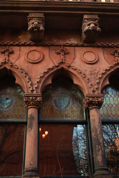 Window facing south in Park Slope on Montauk Club with lion gargoyles and Venetian Gothic architectural elements. 