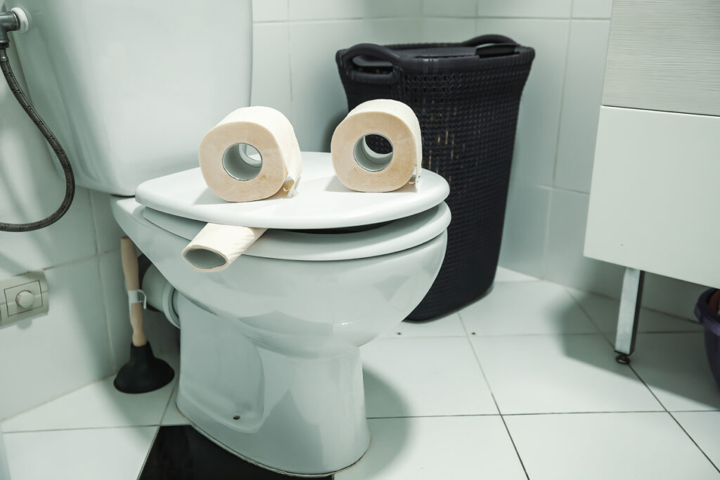 A comical picture of a toilet. It is made to look like it is smiling and smoking a cigarette.