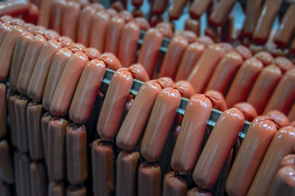 A photograph of sausages being made in a factory. A Coney Island 4th of July isn't complete without a Nathan's wiener, or a thousand.