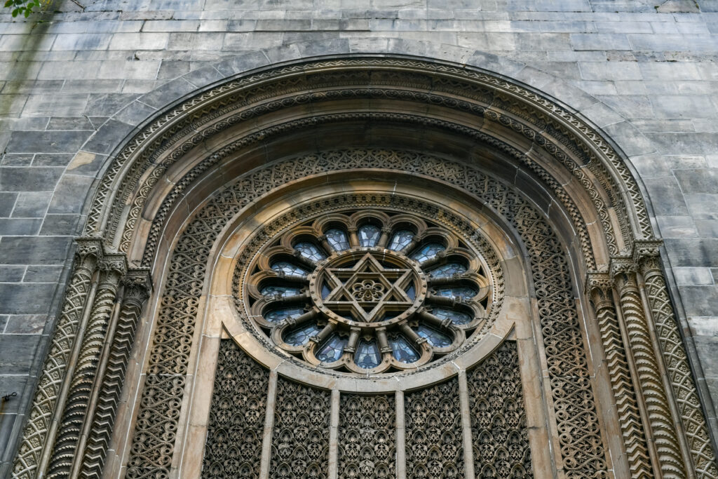 A photograph of a Moorish relief around a Star of David in the center of stained glass at Congregation Ohab Zedek in Manhattan. Synagogues in Manhattan Beach were vandalized.