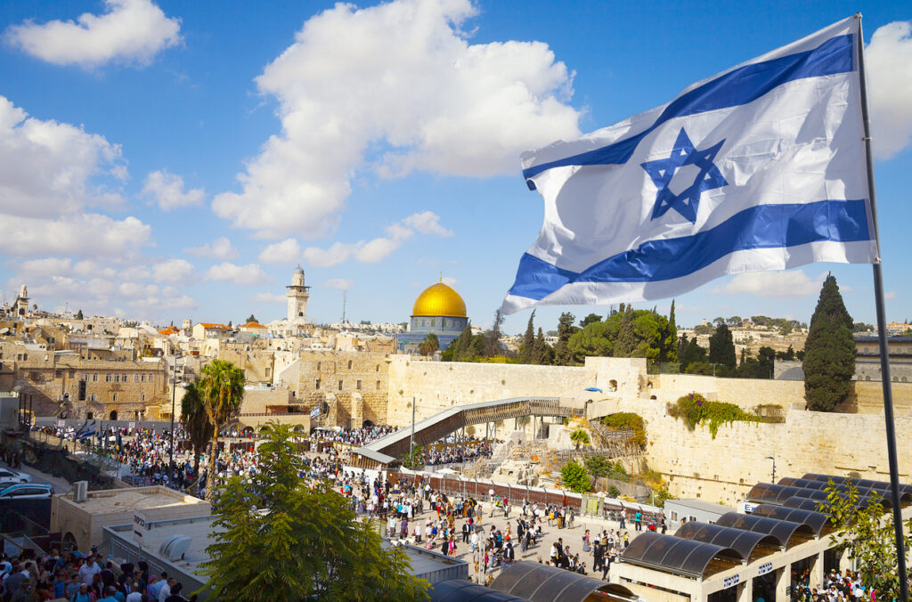 An Israel flag waves over Jerusalem, a point of contention in the Israel-Hamas War.