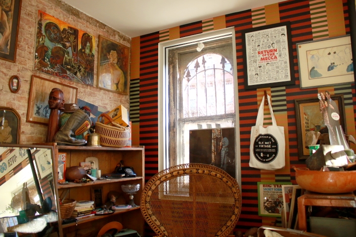 A colorful, striped wallpaper dispalying African art and cultural posters. 